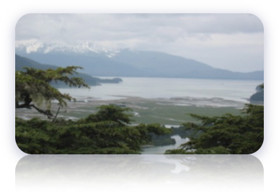 Picture of snow capped mountains bordering on calm lake.